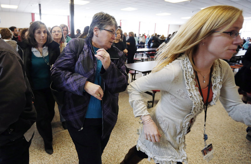 Participants rush out of the cafeteria after hearing gun shots during a lockdown exercise at Milford High School in Milford, Mass., Friday, March 15, 2013. More than 500 teachers, administrators, cafeteria workers and school custodians participated in the training program that taught about alternatives to staying in lockdown during a school shooting, including fighting back. (AP Photo/Michael Dwyer)