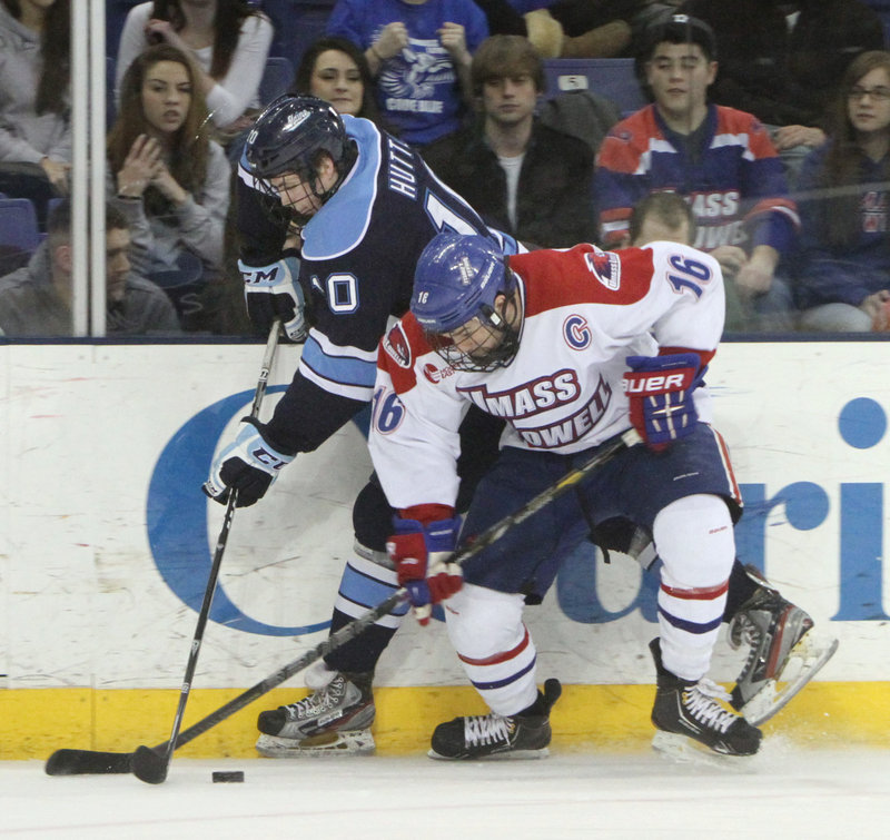 Maine’s Ben Hutton, left, and UMass-Lowell’s Riley Wetmore vie for the puck during the first period Friday night.