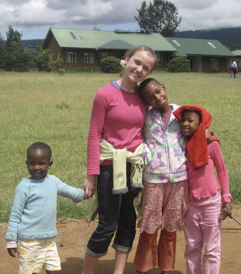 Holly Perkins poses with children at an orphanage in Tanzania during a visit two years ago. She plans to teach ballet there when she returns this month.