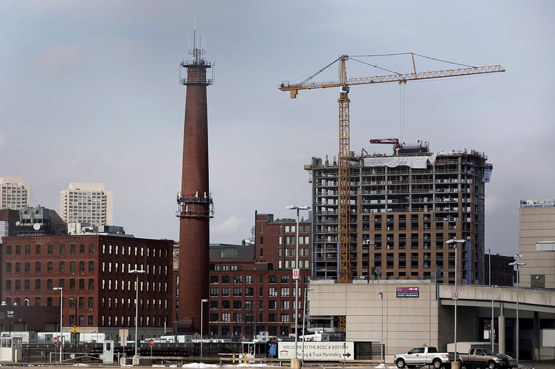 A crane stands on the top of a high-rise building under construction on A Street in Boston. Developers and investors drawn to Boston’s expanding life sciences and technology industry, along with a growing work force of educated young adults, are fueling a boom in construction.