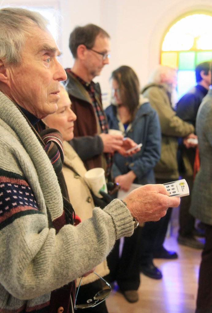 Frank Reilly, left, and his wife, Sharon, of York Street, use hand-held clickers to vote on India Street neighborhood photographs during an informal open house Saturday.