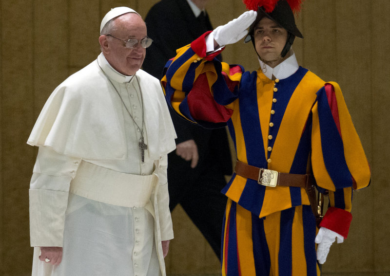 Pope Francis walks past a Swiss guard as he arrives for a meeting with the news media at the Pope VI hall at the Vatican on Saturday.