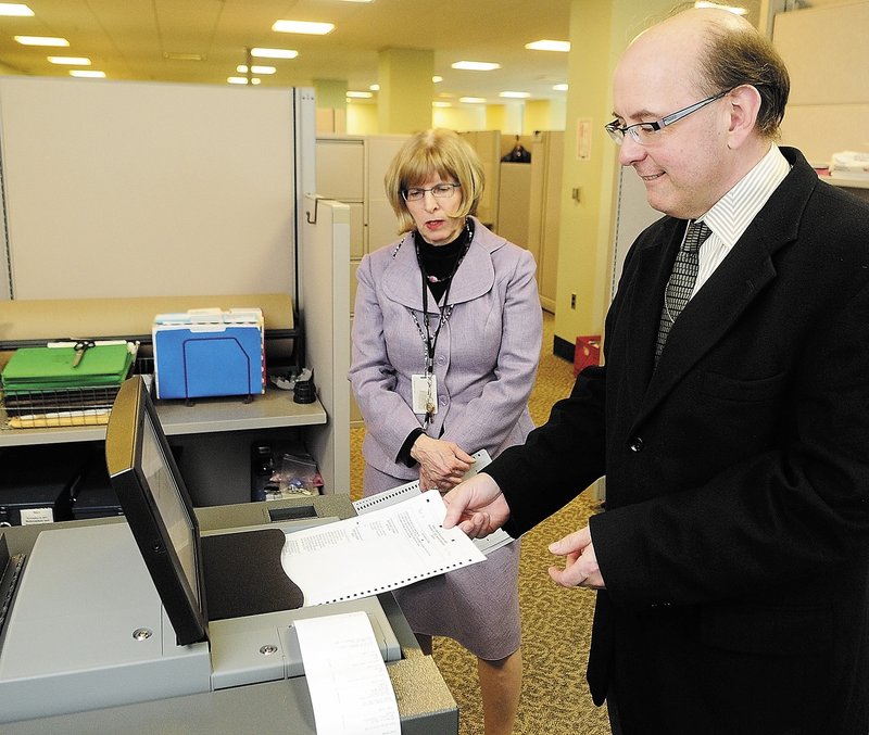 Deputy Secretary of State Julie Flynn, left, and Secretary of State Matt Dunlap demonstrate a vote tabulator last week in Augusta. Litchfield recently rejected a second offer by the state for a machine to tabulate state and federal election ballots in favor of continuing hand-counting.