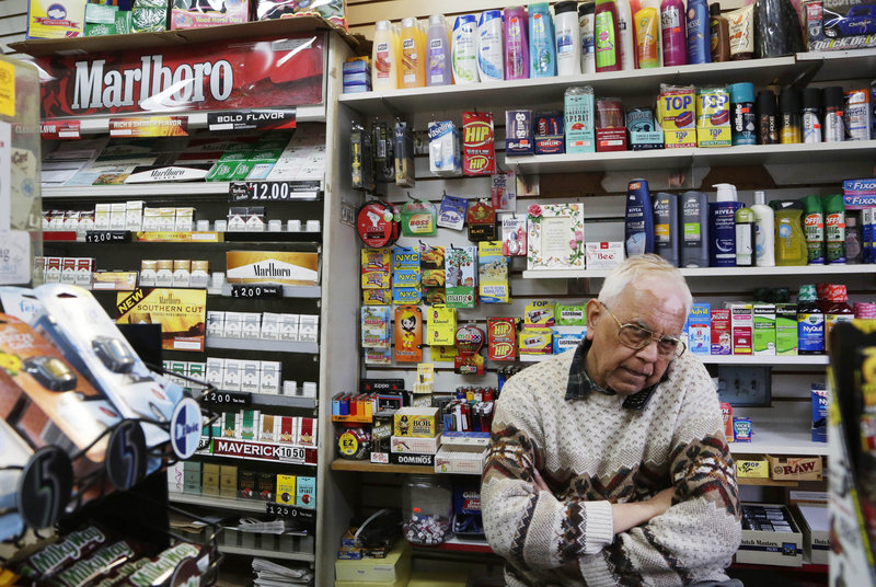 Employee Harry Patel takes a call Monday at Blondie’s Deli and Grocery in New York. Under a pioneering citywide proposal, the store’s tobacco products would be stored out of sight.