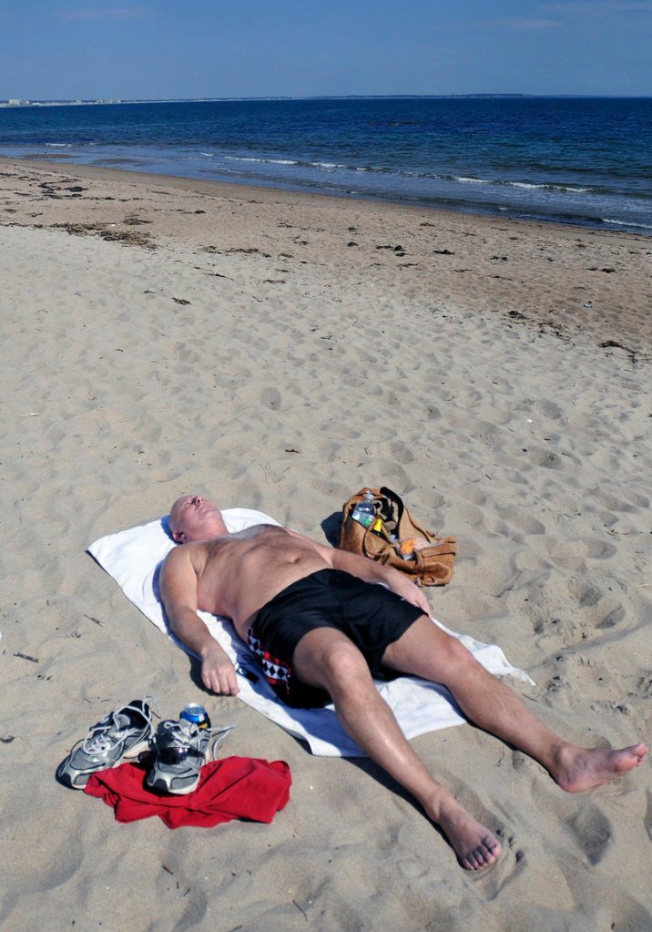 In this March 19, 2012 file photo, Rich Breton of Saco catches some sun rays on an unseasonably warm Monday at Bayview Beach in Saco. What a difference a year makes – Mainers on March 19, 2013 were digging out from the latest snowstorm.