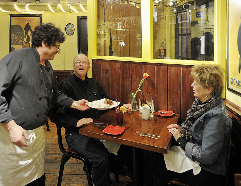 The Merry Table owner and executive chef Jean Claude Vassalle delivers a dessert crepe to Bob and Carolyn Scholl of Connecticut.