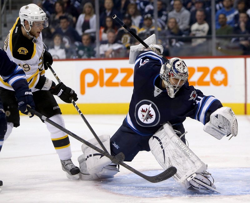 Ondrej Pavelec of the Jets makes a sprawling save with Boston’s Tyler Seguin in front of the net during the first period Tuesday night in Winnipeg, Manitoba. The Jets rallied in the third period for a 3-1 win.
