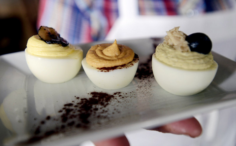 Skye Bonney, sous chef at The Black Birch in Kittery, presents three of her deviled egg specialties: From left, foie gras and truffle, chipotle and cocoa, and nicoise.