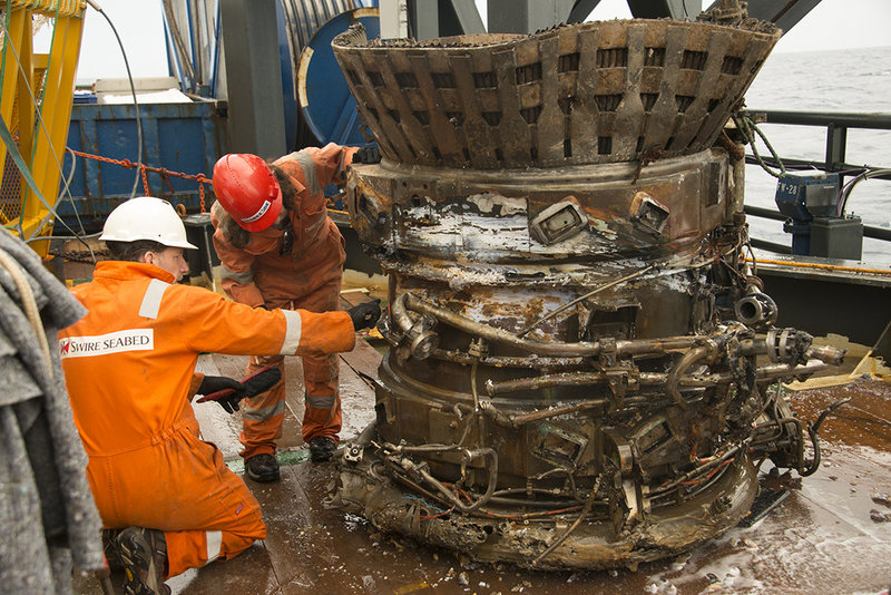 Workers inspect part of an Apollo rocket engine recovered from the bottom of the Atlantic Ocean. Amazon.com CEO Jeff Bezos and NASA announced the recovery Wednesday.