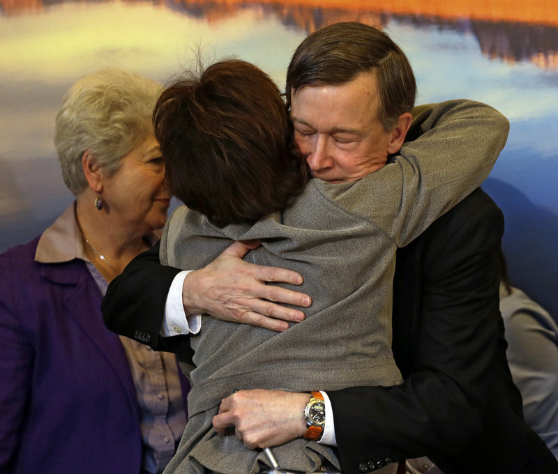 Colorado Gov. John Hickenlooper gets a hug from Rep. Rhonda Fields, D-Aurora, after he signed gun-control bills into law at the Capitol in Denver on Wednesday. Fields co-sponsored bills requiring background checks and limiting the size of ammunition magazines.