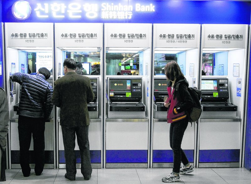 Customers try to use automated teller machines in Seoul. Computer networks at major South Korean banks and television broadcasters crashed simultaneously Wednesday.