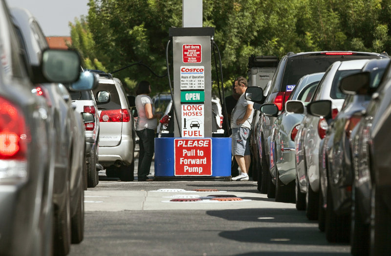 Costco members fill up with discounted gasoline at a Costco gas station in Van Nuys, Calif., in this Oct. 5, 2012, file photo. U.S. oil output rose 14 percent to 6.5 million barrels per day in 2012, a record increase, but you’d never know it from the price at the pump.