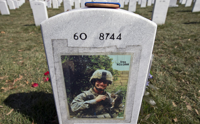 A photo is attached to the back of the tombstone of Army 1st Lt. Thomas J. Brown, a casualty of the Iraq war, in Arlington National Cemetery. “The war had three unique phases, each requiring a change in political and military policies,” says a Marine veteran.