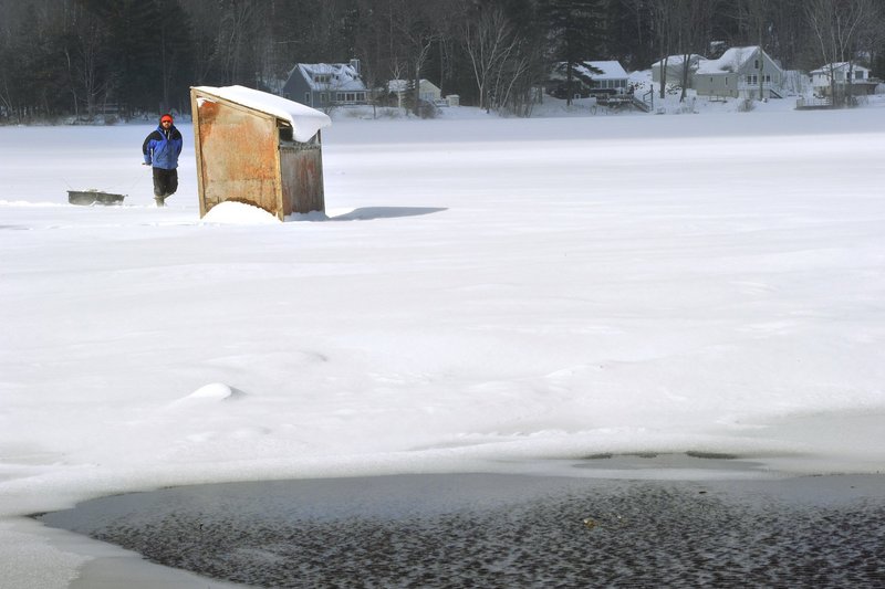 An ice fisherman on Kennebunk Pond in Lyman on Wednesday makes his way to his ice-fishing shack, which was located about 100 yards from open water near the public boat launch.