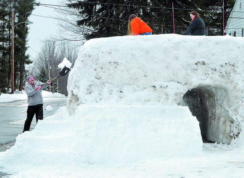 Steven St. Pierre tosses a shovelful of snow Wednesday onto a snow fort he and his daughters Shania St. Pierre, 14, center, and Natasha St. Pierre, 18, are building on Sixth Avenue in Augusta.