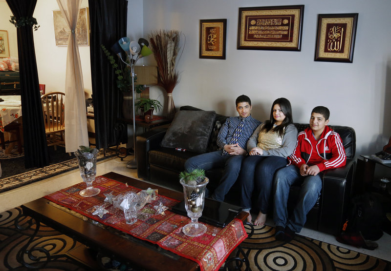 Ahmed, 14, Sandra, 17, and Mohammed Banijameel, 12, sit in their Westbrook home. The Banijameel family, originally from Iraq, moved to Westbrook after living in Portland.