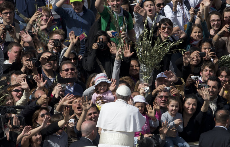 Pope Francis is cheered by a crowd estimated at 250,000 after celebrating his first Palm Sunday Mass as pope in St. Peter’s Square at the Vatican on Sunday.