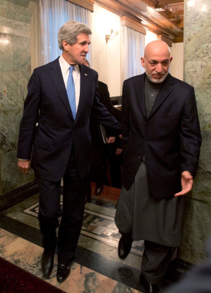 Secretary of State John Kerry walks with Afghan President Hamid Karzai to a meeting at the Presidential Palace in Kabul on Monday.