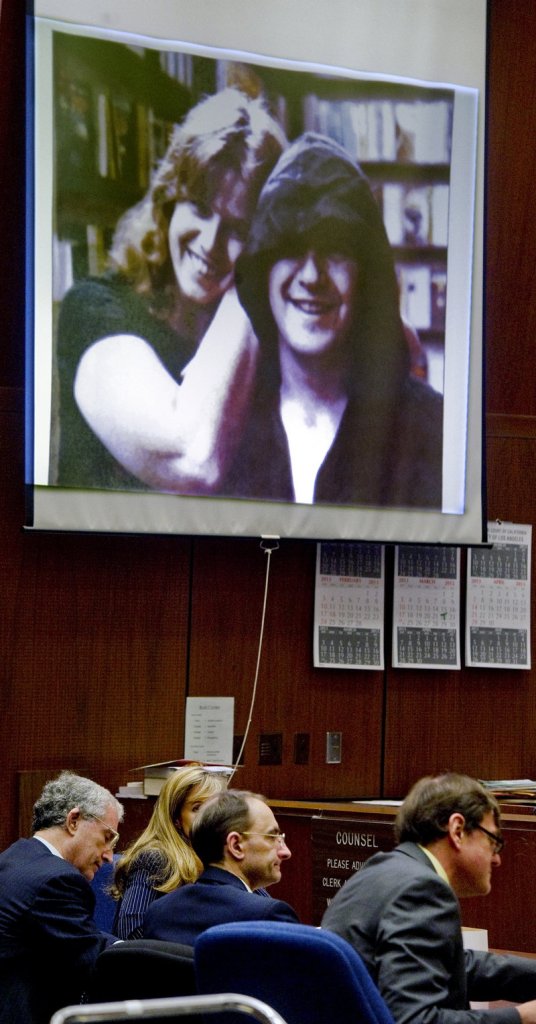 Christian Karl Gerhartsreiter, center, sits with his lawyers in front of a projected photo of Linda and John Sohus in a Los Angeles courtroom Monday.