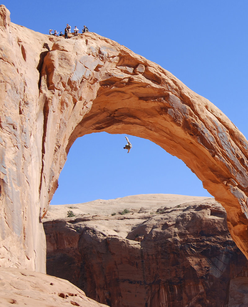 A person swings from the Corona Arch near Moab, Utah, in November. A 22-year-old man was killed Sunday, trying to swing through the opening of the 110-foot-tall, sandstone arch in a stunt made popular on YouTube.