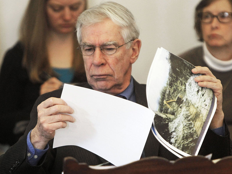 Sen. Donald Collins, D-Franklin, looks at photos of mountaintop wind projects during debate on Tuesday, March 26, 2013 in Montpelier, Vt.