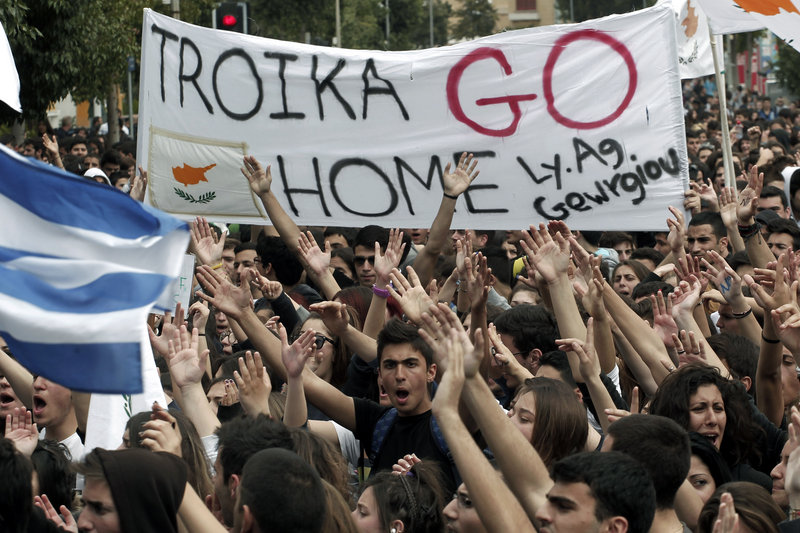 Cypriot students shout slogans near the presidential palace in the capital of Nicosia on Tuesday. Banks across Cyprus remained closed on Tuesday.