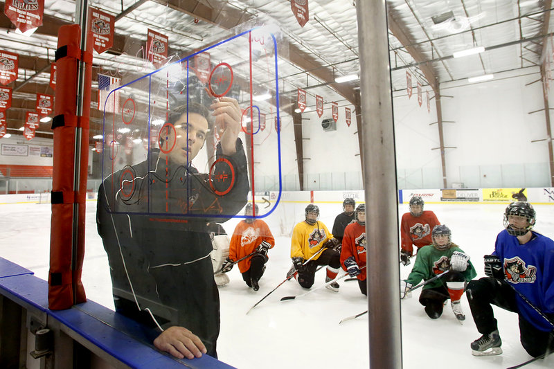 Matt Libby, coach of the Portland Junior Pirates girls’ U19 team, diagrams instructions at the MHG Ice Center in Saco on Thursday. And Libby has a lot to offer – he played for both Providence College and professionally for the Portland Pirates.