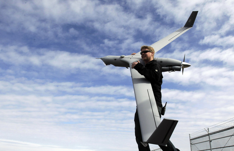 Flight test pilot Alex Gustafson carries an InsituScanEagle unmanned aircraft at Arlington, Ore. Advocates cite numerous examples, from agriculture to mapping, where drones can be valuable as low-cost surveillance tools.