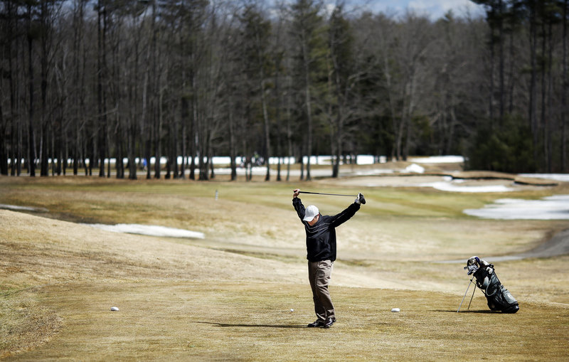 Scott Moulton of Auburn stretches before taking his first shot of the season, hitting off the first tee at Nonesuch River. Nonesuch is traditionally the first course in the area to open.