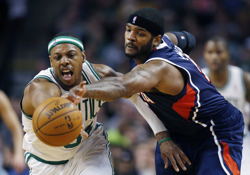 Boston’s Paul Pierce, left, battles for a loose ball with Atlanta’s Josh Smith. Pierce shook off a minor leg injury to collect 20 points, 10 assists and 10 rebounds in leading the Celtics past the Hawks, 118-107.