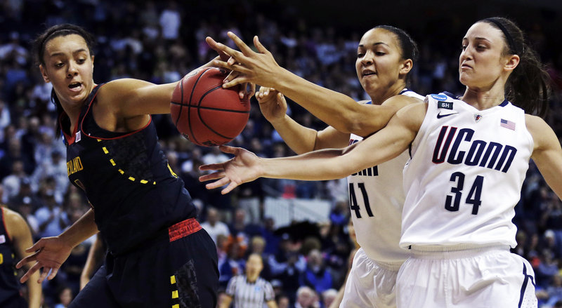 Malina Howard, left, of Maryland reaches for a rebound along with Connecticut’s Kiah Stokes, center, and Kelly Faris during UConn’s 76-50 victory Saturday in Bridgeport, Conn.