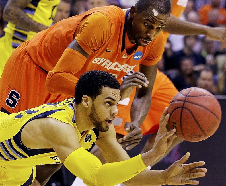 Marquette guard Trent Lockett (22) passes the ball away from Syracuse center Baye Keita (12) during the first half of the East Regional final in the NCAA men's college basketball tournament,Saturday in Washington.