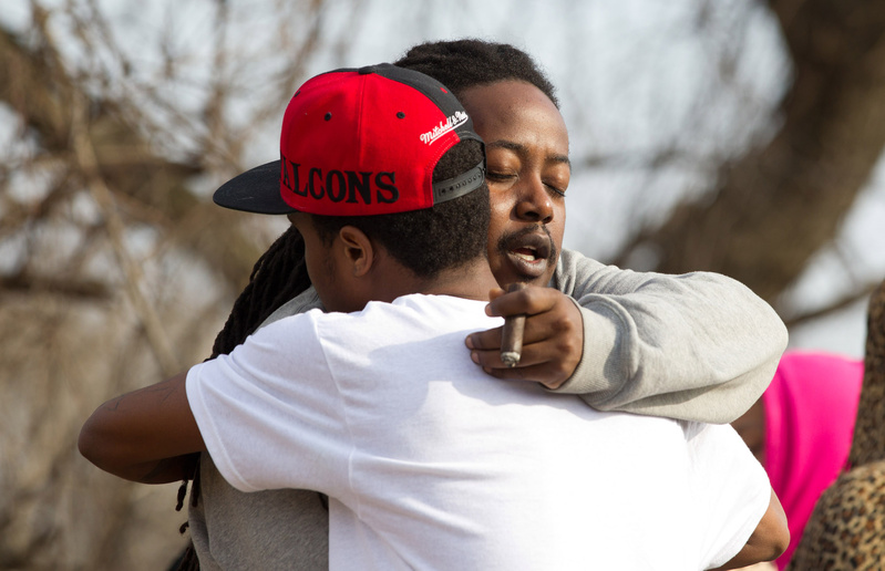 Leaman Joe, left, hugs Michael Parker at the site of the crash that killed their friends in Warren, Ohio, on Sunday.
