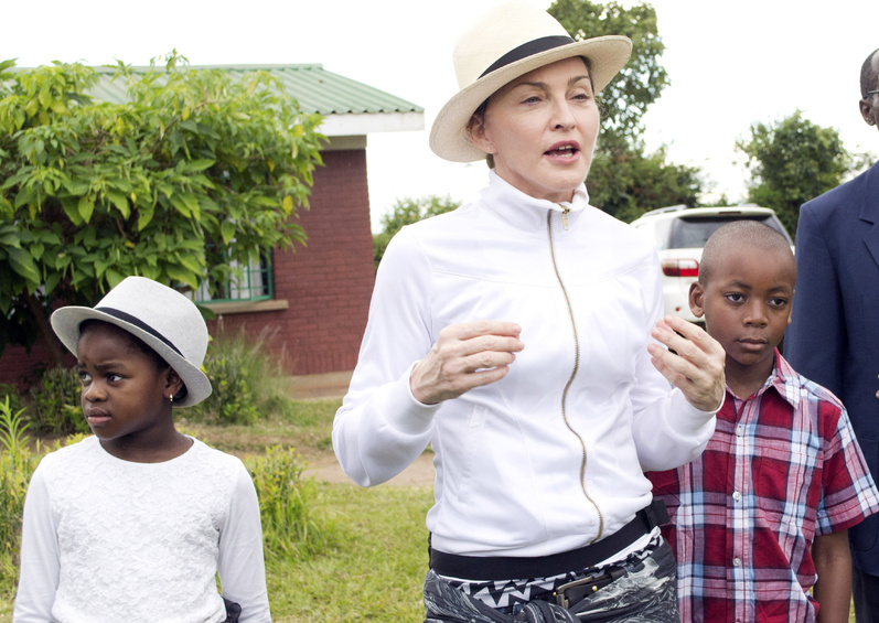 Pop singer Madonna tours an orphanage last week near Lilongwe, the capital, with children she adopted in Malawi, David Banda, right, and Mercy James.
