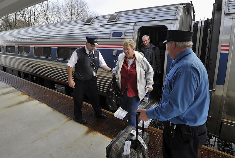 In this Dec. 19, 2012 file photo, Downeaster conductor Chuck Moyer, left, helps passenger, Jean Townsend, who lives in Naples Forida, as she departs the train in Freeport to visit her children for Christmas. Town Manager Peter Joseph proposed a $4.85 million town budget Tuesday, April 23, 2013 that would largely maintain funding for municipal services while accounting for increased costs for the operation of Freeport's train station.