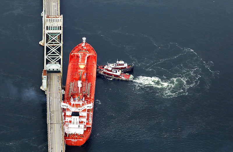 Seen in this aerial photograph, tugboats hold the Harbour Feature in place against the Sarah Mildred Long Bridge in Kittery on Monday, April 1, 2013, after it slipped off its moorings at the New Hampshire State Pier.