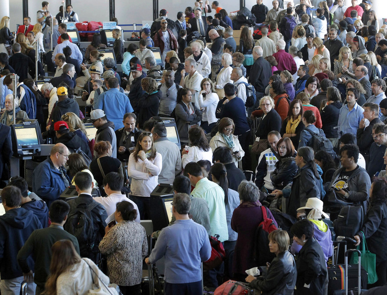 Passengers gather at the American Airlines check-in for flights at Los Angeles International Airport on Tuesday. Computer problems forced American Airlines to ground flights across the country after the airline was unable to check in and book passengers.