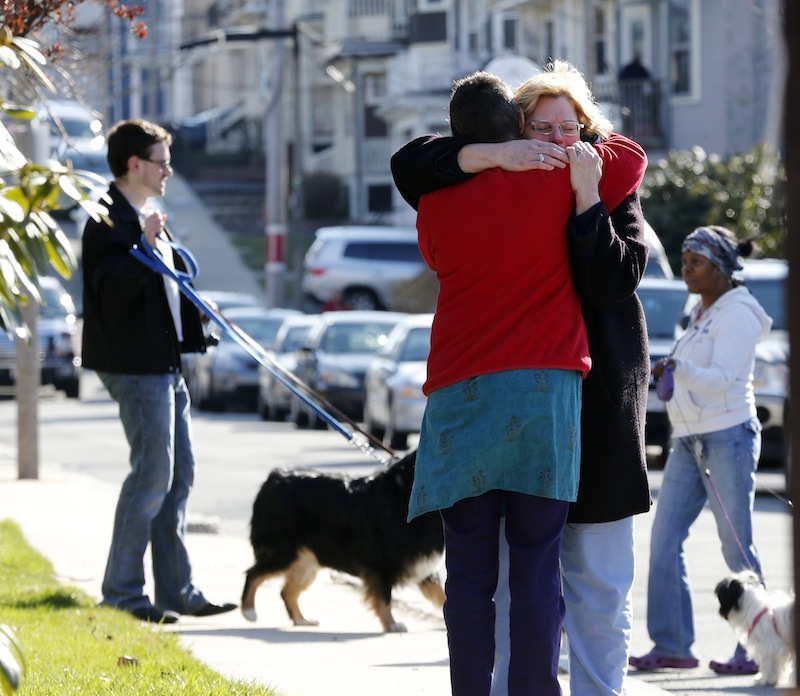 Neighbors hug outside the home of the Richard family in the Dorchester neighborhood of Boston, Tuesday, April 16, 2013. Martin Richard, 8, was killed in Monday's bombing at the finish line of the Boston Marathon. (AP Photo/Michael Dwyer)