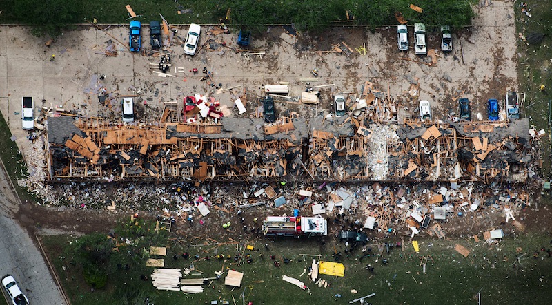 In this aerial photo, law enforcement and rescue personnel search the damage to an apartment complex from the explosion of the West Fertilizer plant on Thursday, April 18, 2013, in West, Texas.