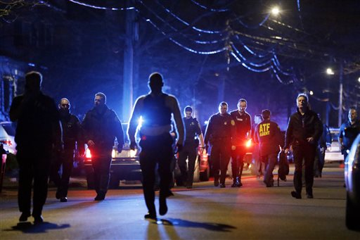 Police converge on a neighborhood where residents heard gunfire and explosions Friday in Watertown, Mass. A tense night of police activity that left a university officer dead on campus just days after the Boston Marathon bombings and amid a hunt for two suspects.