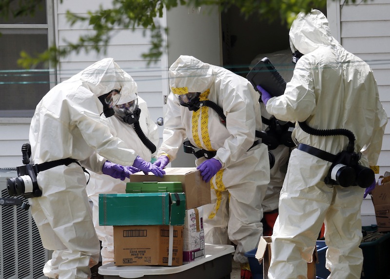 Federal agents wearing hazardous material suits and breathing apparatus inspect the home and possessions in the West Hills Subdivision house of Paul Kevin Curtis in Corinth, Miss., Friday, April 19, 2013. The charges against Curtis were dropped Tuesday, April 23, 2013. (AP Photo/Rogelio V. Solis)