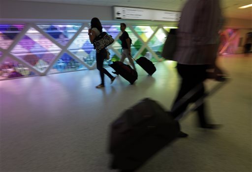 Passengers travel through an airport in Miami recently. "The way airlines have taken 130-seat airplanes and expanded them to 150 seats to squeeze out more revenue I think is finally catching up with them," says Dean Headley, a business professor at Wichita State University.
