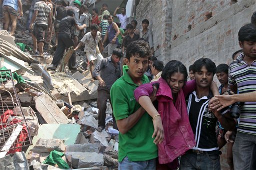 Rescuers assist an injured woman after an eight-story building housing several garment factories collapsed in Savar, near Dhaka, Bangladesh, on Wednesday.