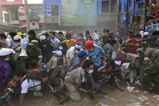 Bangladeshi rescue workers and media fall on top of each other in a stampede aftersomeone shouted that a section of building might collapse in Savar, Bangladesh, on Friday.