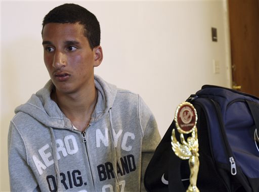 Salah Eddin Barhoum, 17, sits in his apartment in Revere, Mass., on Thursday with one of the trophies he won in an athletic competition, and the bag he was carrying on Monday near the finish line of the Boston Marathon. The high school student, of Moroccan descent, said he is scared to go outside after he was portrayed on the Internet and on the front page of the New York Post as connected to the deadly Boston Marathon bombings.