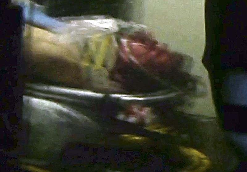 This still frame from video shows Boston Marathon bombing suspect Dzhokhar Tsarnaev visible through an ambulance after he was captured in Watertown, Mass., Friday, April 19, 2013.A 19-year-old college student wanted in the Boston Marathon bombings was taken into custody Friday evening after a manhunt that left the city virtually paralyzed and his older brother and accomplice dead. (AP Photo/Robert Ray) Mass Police Converge