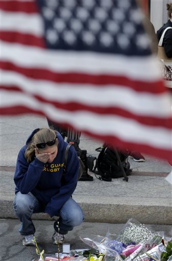 Jillian Blenis, 30, of Boston, reacts while stopping at a makeshift memorial on Wednesday in Boston.