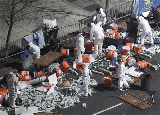 Investigators comb through the post finish line area of the Boston Marathon at Boylston Street on Wednesday, two days after two bombs exploded just before the finish line.