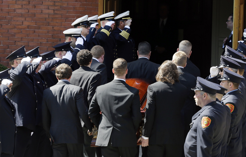 An honor guard from local fire departments salute as pallbearers carry the casket of Boston Marathon bomb victim Krystle Campbell, 29, into St. Joseph's Church for her funeral in Medford, Mass., on Monday.