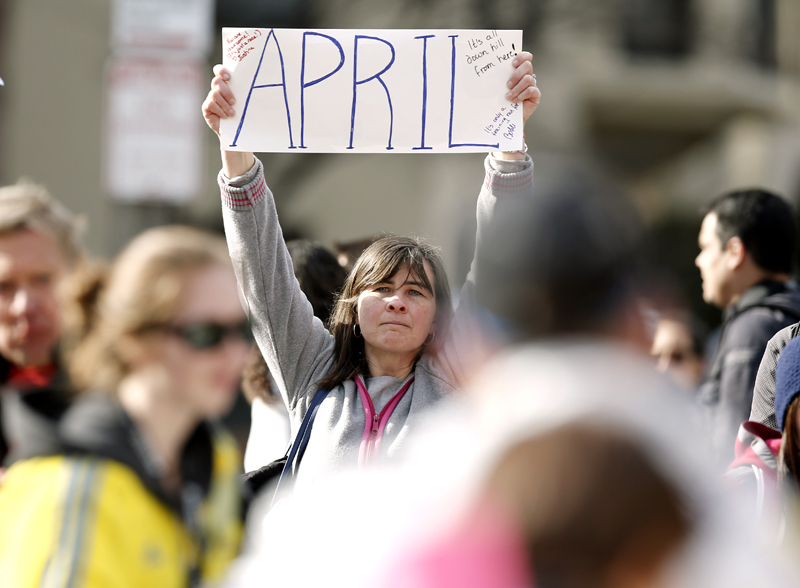 Justine Franco of Montpelier, Vt., holds up a sign near Copley Square in Boston looking for her missing friend, April, who was running in her first Boston Marathon Monday, April 15, 2013. Two bombs exploded near the finish line of the marathon on Monday, killing at least two people and injuring at least 23 others. (AP Photo/Winslow Townson)